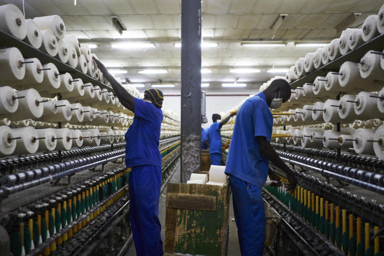 Des ouvriers disposent des bobines de coton sur les machines à la Société Malienne de Textile (COMATEX) à Ségou, le 12 décembre 2018. MICHELE CATTANI AFP