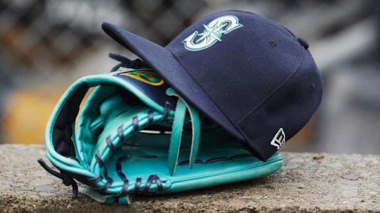 A Seattle Mariners hat and glove is pictured in the dugout before a game against the Detroit Tigers on May 12, 2018, at Comerica Park. | Rick Osentoski-Imagn Images