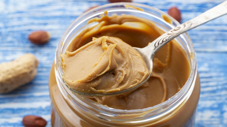 Peanut butter being spooned out of jar