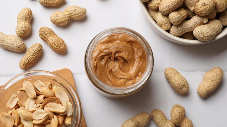 Jar of peanut butter with shelled and unshelled peanuts