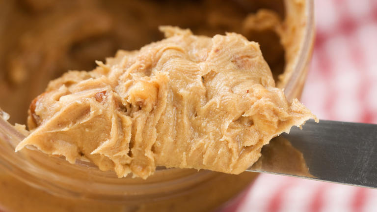 Heap of crunchy peanut butter on knife