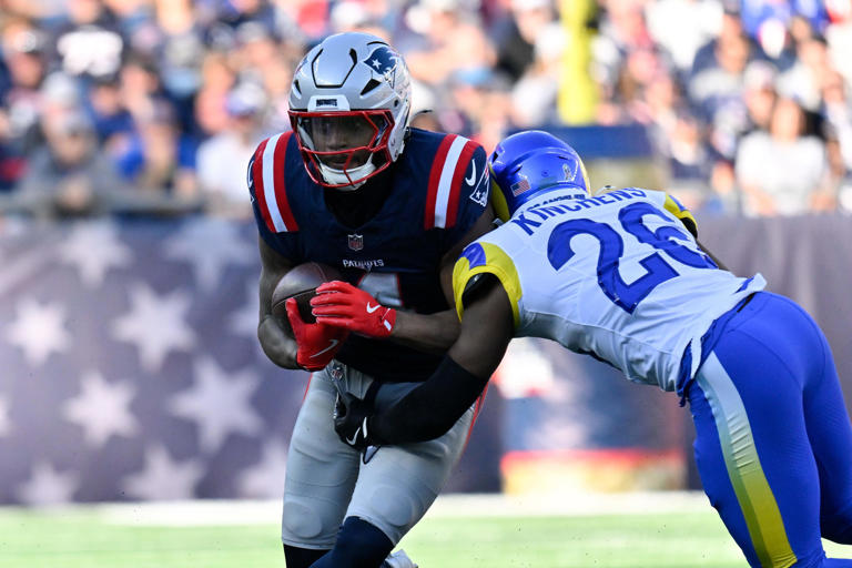 Nov 17, 2024; Foxborough, Massachusetts, USA; New England Patriots running back Antonio Gibson (4) is tackled by Los Angeles Rams safety Kamren Kinchens (26) during the first half at Gillette Stadium. Mandatory Credit: Eric Canha-Imagn Images