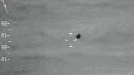 A still from a video reportedly showing a "transmedium" UAP that appears to travel between air and water and split in half. During testimony on Nov. 19, the head of the Pentagon's UFO office says it actually shows an infrared camera's inability to tell two objects' temperature apart from the ocean behind them. (Image credit: AARO/DOD)