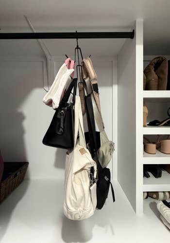 Various handbags hanging on a metal rod in a closet; shelves with shoes and folded clothes visible in the background