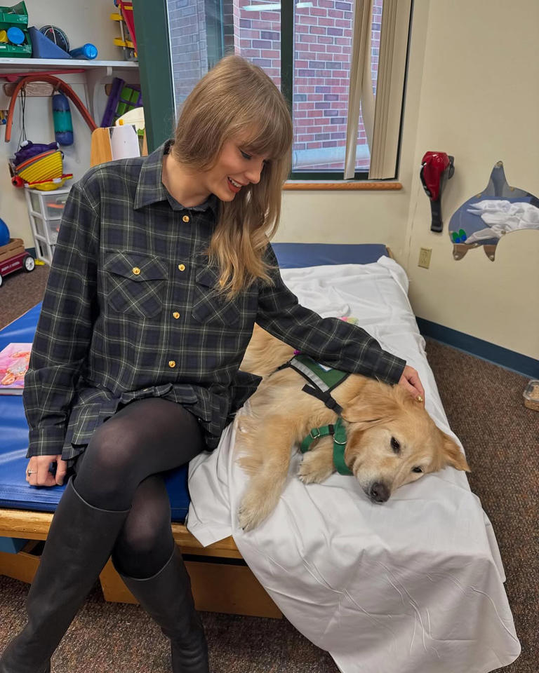 Swift wore a plaid Miu Miu set and knee-high leather boots. (Image credit: @tailsofkcfacilitydogs)