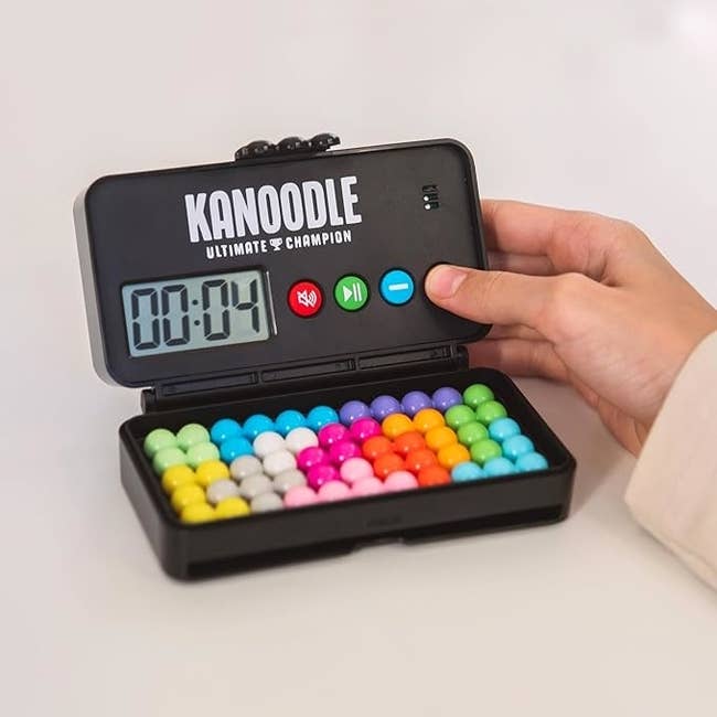 Person holding a Kanoodle Ultimate Challenge game