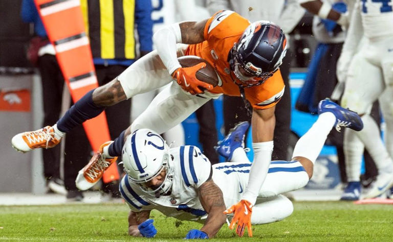 December 15, 2024, Denver, Colorado, USA: Broncos CB PAT SURTAIN II gets tackled hard by the Colts after an interception during the 2nd. Half at Empower Field at Mile High Sunday afternoon.The Broncos beat the Colts 31-13. Denver USA – ZUMAav4_ 20241215_zaf_av4_045 Copyright: xHectorxAcevedox