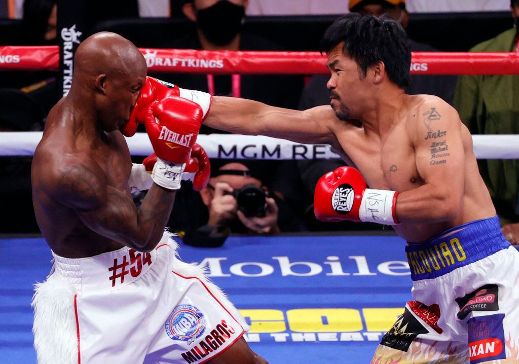 Manny Pacquiao (R) hits Yordenis Ugas in the first round of their WBA welterweight title fight at T-Mobile Arena on August 21, 2021 in Las Vegas, Nevada. (Photo by Ethan Miller/Getty Images)