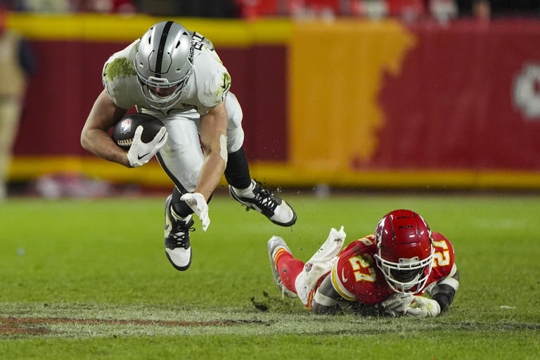 Las Vegas Raiders tight end Brock Bowers (89) is tackled by Kansas City Chiefs safety Chamarri Conner (27) during the second half of an NFL football game in Kansas City, Mo., Friday, Nov. 29, 2024. (AP Photo/Charlie Riedel)