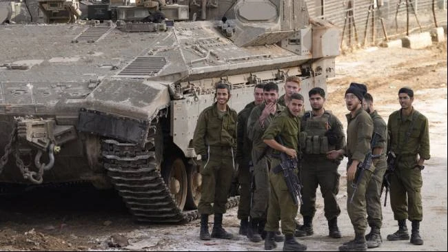 Tentara Israel berkumpul di dekat sebuah kendaraan lapis baja di dekat apa yang disebut Garis Alfa yang memisahkan Dataran Tinggi Golan, wilayah Suriah yang dicaplok Israel, dan Suriah, di kota kecil Majdal Shams, Senin (9/12/2024).
