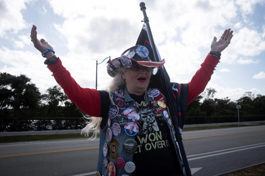  A supporter of U.S. President-elect Donald Trump reacts as the motorcade carrying him drives past to his residence at Mar-a-Lago in Palm Beach, Florida, U.S., December 12, 2024. REUTERS/Marco Bello 