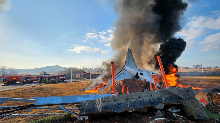 The South Korean passenger plane on fire in the aftermath of the crash at at Muan International Airport. Pic: Reuters