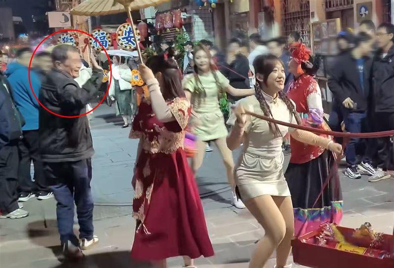 阿北得逞後溜了，還不忘回頭揮手露出詭異笑容。（圖／翻攝自廟會隨手拍臉書）