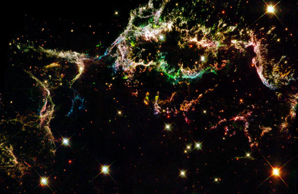 De kleurrijke filamenten van Cas A, bestaande uit geïoniseerde gassen, geven inzicht in de ontploffingsmechanismen en de samenstelling van massieve sterren. De data die door de Hubble-telescoop worden verzameld, helpen astronomen om de chemische verrijking van het heelal na een supernova beter te begrijpen. Foto: NASA/ESA and The Hubble Heritage Team (STScI/AURA)