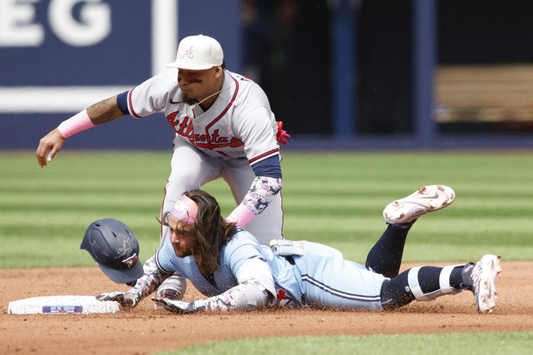 TORONTO, ON - MAY 14: Orlando Arcia #11 of the Atlanta Braves tags Bo Bichette #11 of the Toronto Blue Jays at second as he tries to stretch an extra base hit in the fourth inning of their MLB game at Rogers Centre on May 14, 2023 in Toronto, Canada.