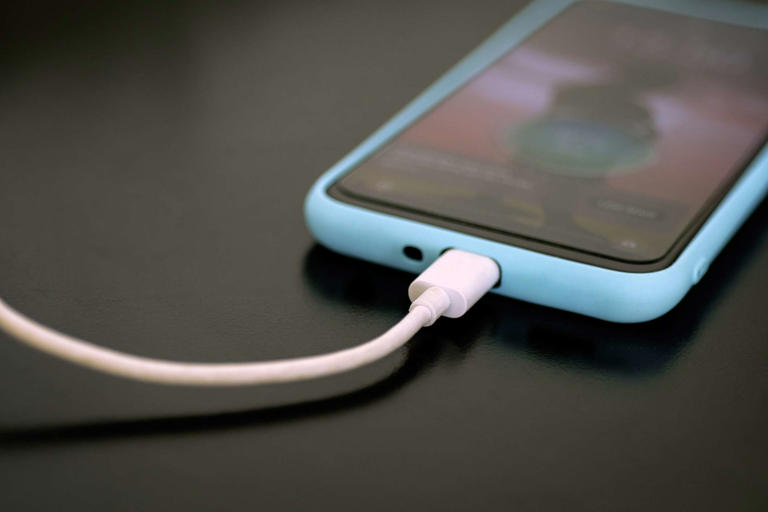Priscila Zambotto / Getty Images Close-up smartphone plugged in.