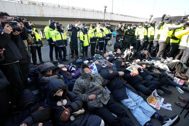 Supporters of impeached Yoon Suk Yeol lie down on the ground during a protest rally outside the presidential palace in Seoul (AP)