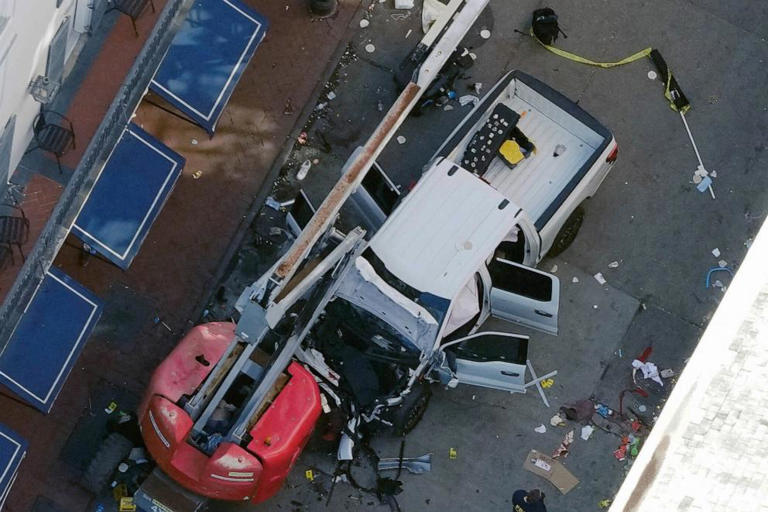 A black flag with white lettering lies on the ground rolled up behind a pickup truck that a man drove into a crowd on Bourbon Street in New Orleans, early Wednesday morning, Jan. 1, 2025.