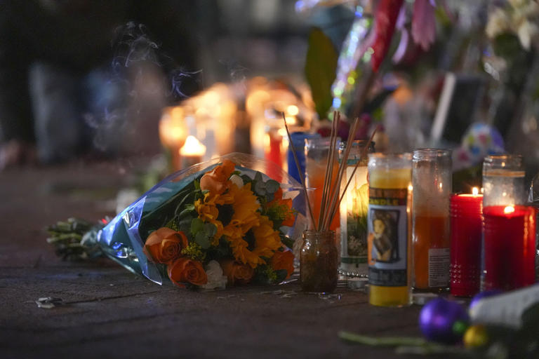 Flowers lie next to candles at a memorial for the victims of the attack (Gerald Herbert/AP) (AP)