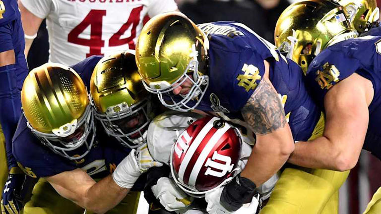 Notre Dame Fighting Irish defensive lineman Joshua Burnham (40) and teammates tackle Indiana Hoosiers wide receiver Myles Price (4) during the third quarter at Notre Dame Stadium. | Matt Cashore-Imagn Images