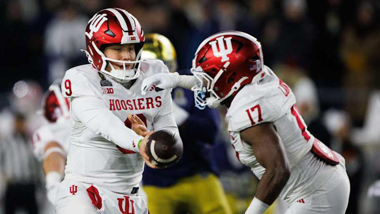 Indiana quarterback Kurtis Rourke (9) hands the ball off to running back Ty Son Lawton (17) during the first round of the College Football Playoff between Notre Dame and Indiana at Notre Dame Stadium on Friday, Dec. 20, 2024, in South Bend. | MICHAEL CLUBB/SOUTH BEND TRIBUNE / USA TODAY NETWORK via Imagn Images