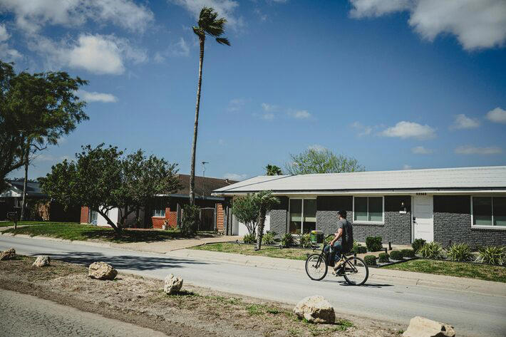 Um homem pedala na Memes Street (Rua dos Memes) em Boca Chica Village, Texas Foto: Meredith Kohut/NYT