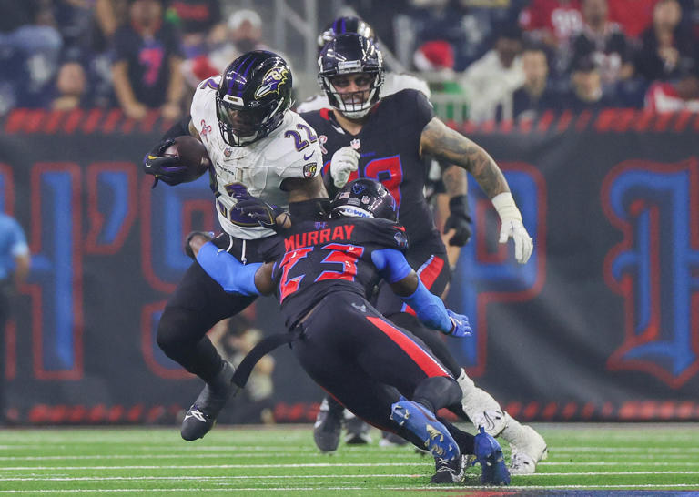 Dec 25, 2024; Houston, Texas, USA; Baltimore Ravens running back Derrick Henry (22) rushes against Houston Texans safety Eric Murray (23) in the second half at NRG Stadium. Mandatory Credit: Thomas Shea-Imagn Images