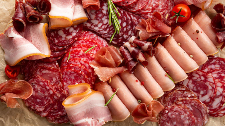 An assortment of deli meats, arranged on brown paper