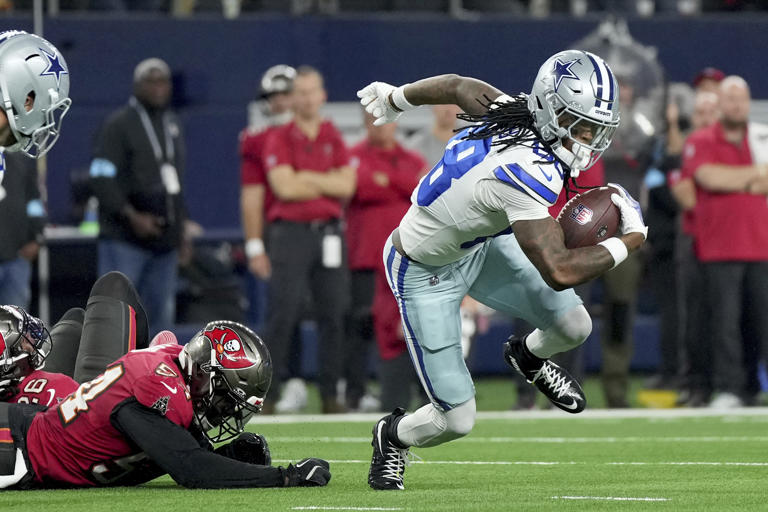 Dallas Cowboys wide receiver CeeDee Lamb (88) breaks a tackle attempt by Tampa Bay Buccaneers linebacker Lavonte David (54) in the first half of an NFL football game in Arlington, Texas, Sunday, Dec. 22, 2024. (AP Photo/Jeffrey McWhorter)