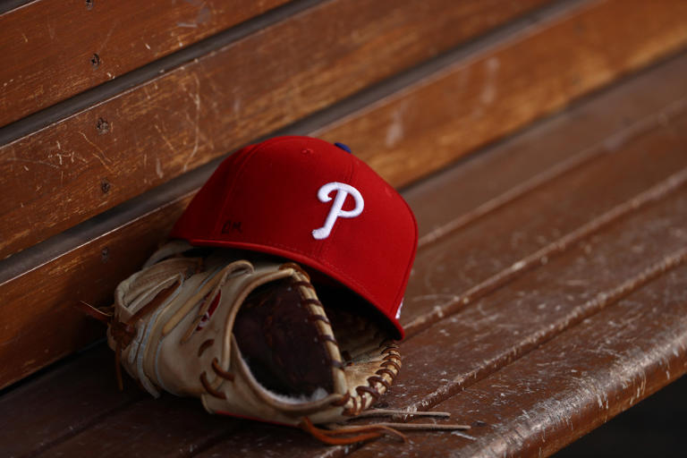 LAKELAND, FL - FEBRUARY 24: A detailed view of a Philadelphia Phillies baseball hat and glove sitting in the dugout during the spring training game against the Detroit Tigers at Joker Marchant Stadium on February 24, 2013 in Lakeland, Florida. The game ended in a 10 inning 5-5 tie. Gary Sutherland died.