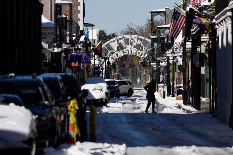 A person walks on a street covered with ice and snow after a rare winter snowstorm churned across the U.S. Gulf Coast, in New Orleans, Louisiana, U.S. January 22, 2025. REUTERS/Shawn Fink TPX IMAGES OF THE DAY