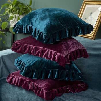 Stack of plush velvet pillows with ruffled edges, ideal for home decor and comfort enhancements