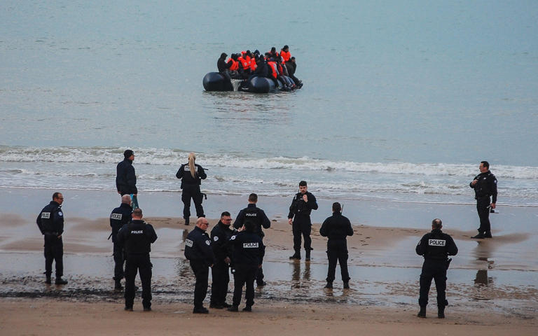 File image of a group of French policemen watching a small boat setting off in an apparent attempt to cross the English Channel