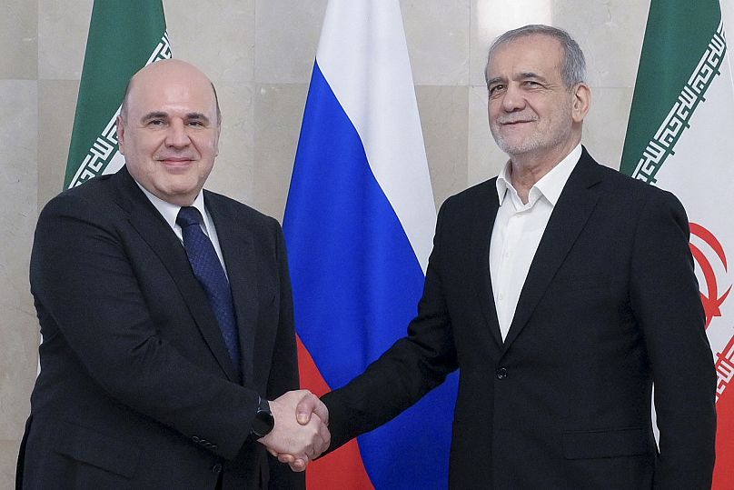 رئيس الوزراء الروسي ميخائيل ميشوستين، إلى اليسار، والرئيس الإيراني مسعود بيزشكيان يقفان لالتقاط صورة قبل محادثاتهما في موسكو، روسيا، الجمعة 17 يناير/كانون الثاني 2025 Alexander Astafyev/Sputnik