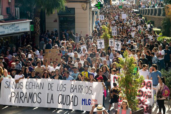 Protesters are seen carrying placards and banners as they...