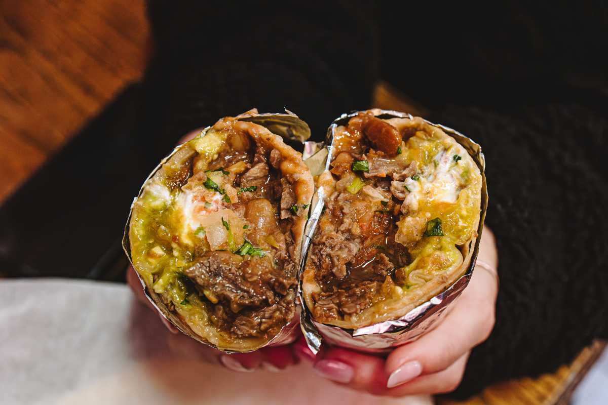 carne asada burrito cut in half to show filling