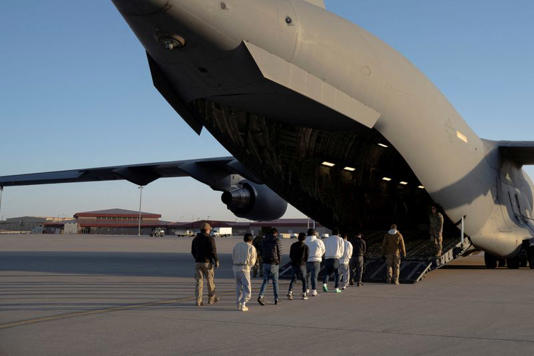 Agentes de segurança conduzem migrantes detidos para embarcar em uma aeronave C-17 Globemaster III da Força Aérea dos EUA para um voo de remoção em Fort Bliss, Texas 23/01/2025 Dept. de Defesa/Sargento do Exército dos EUA Nicholas J. De La Pena/Divulgação via REUTERS