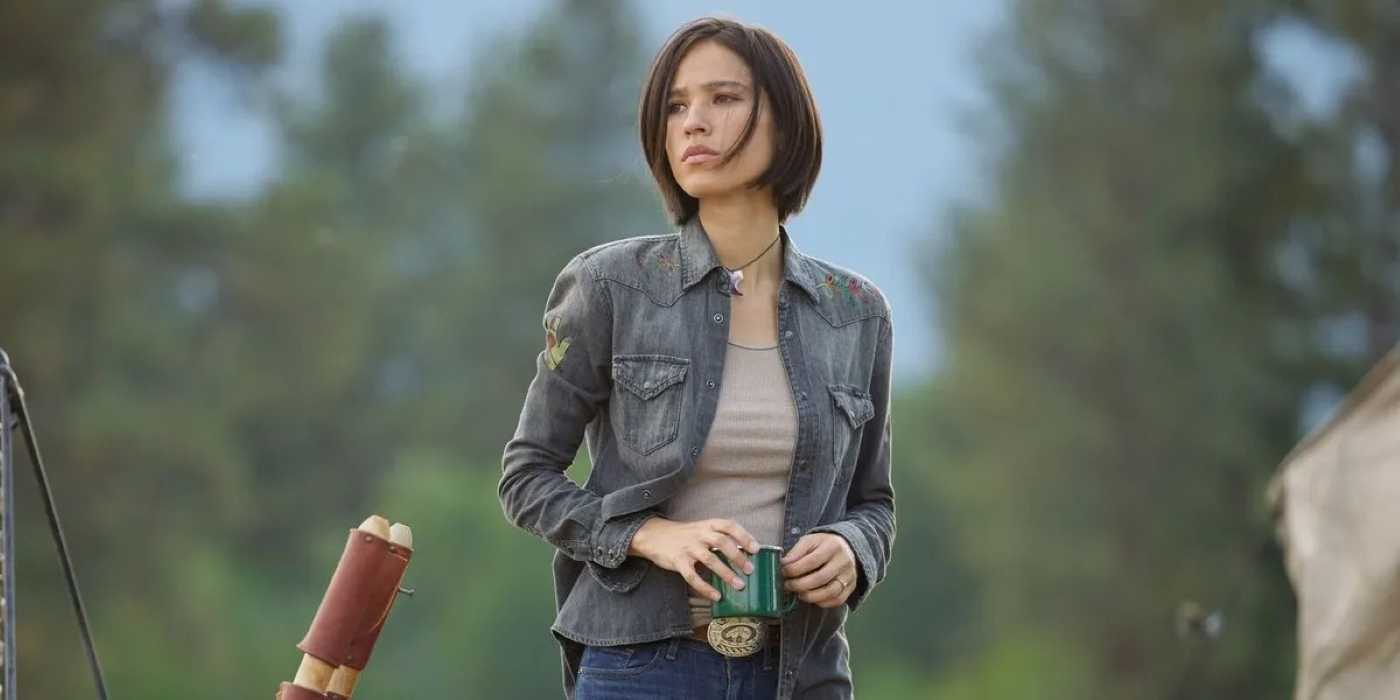 Monica Dutton (Kelsey Asbille) standing with a cup in Yellowstone