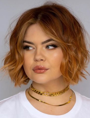 Woman with chin-length, auburn-colored hair styled in tousled waves