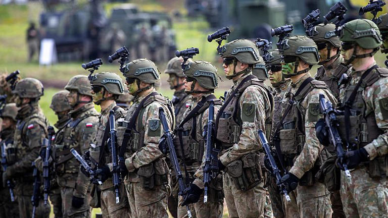 Soldados en formación con vehículos militares