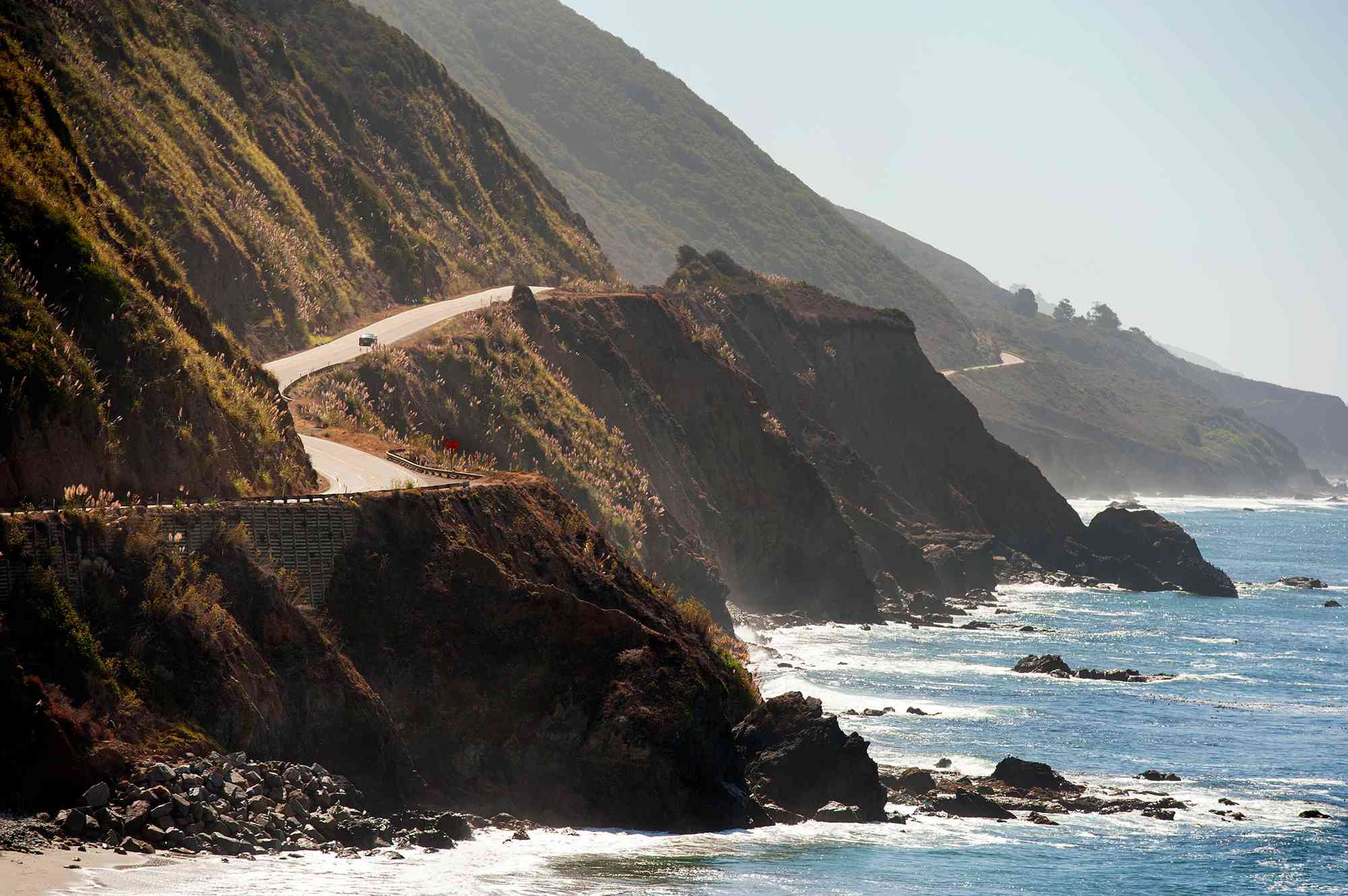 A car driving along the coast near Pfeiffer Big Sur State Park in Monterey County, California