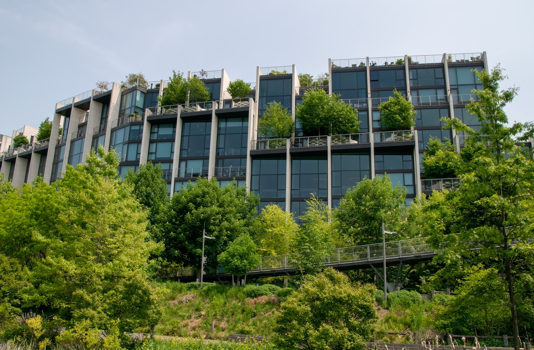 Modern residential building with greenery on balconies.