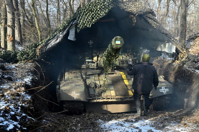 Un soldat ukrainien de la 3e brigade de chars des forces terrestres ukrainiennes camoufle un char T-72 dans un lieu tenu secret dans la région de Kharkiv, le 10 février 2025