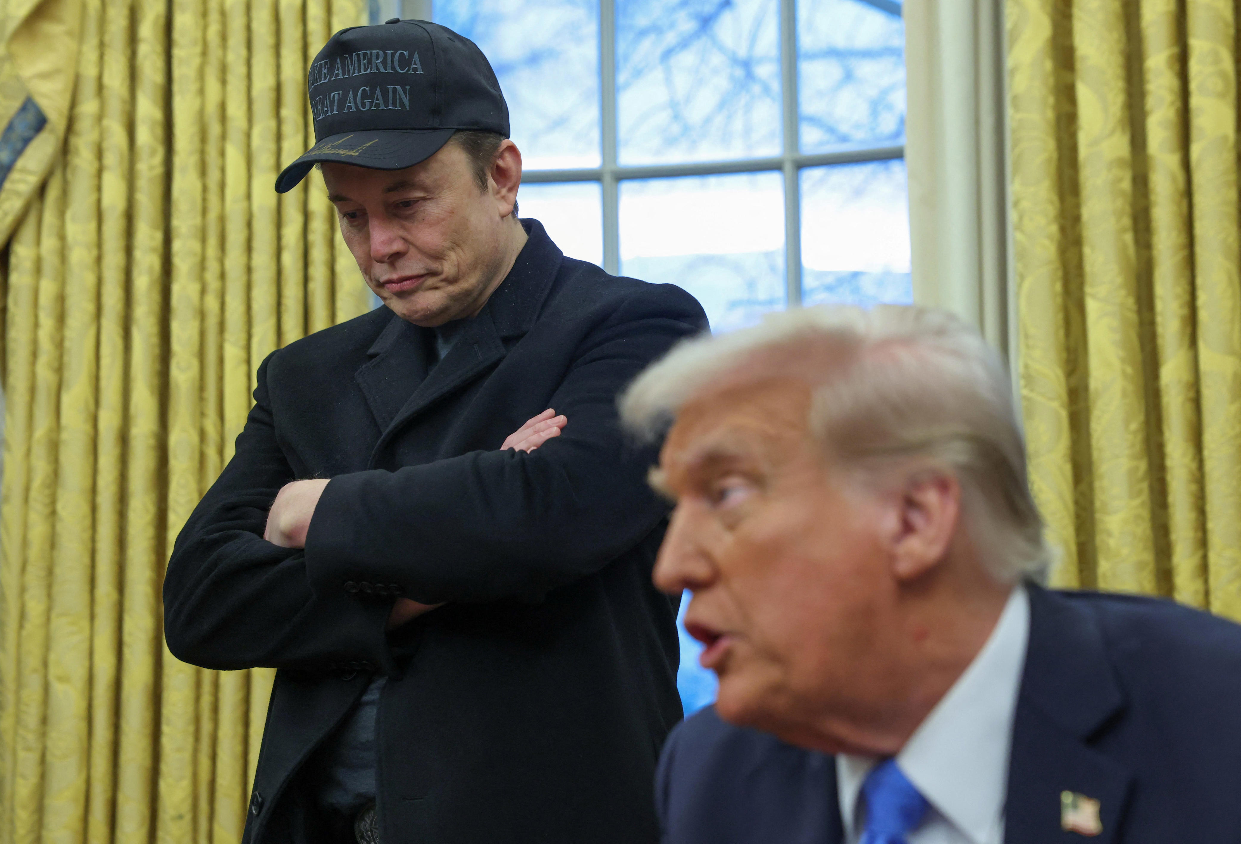 Elon Musk listens to U.S. President Donald Trump speak in the Oval Office of the White House in Washington, D.C.