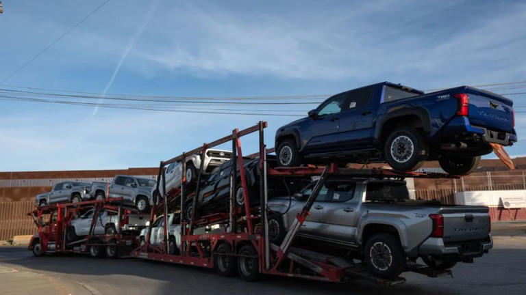 Un camión cargado de camionetas avanza para cruzar a Estados Unidos junto al muro fronterizo en el puerto comercial de Otay en Tijuana, estado de Baja California, México, el 26 de noviembre de 2024. - Guillermo Arias/AFP/Getty Images/File