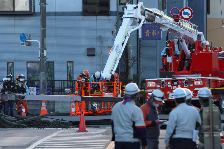 Rescue work continues to save a truck driver whose vehicle was swallowed by a sinkhole in the city of Yashio, Saitama Prefecture, Japan (JIJI Press/AFP via Getty)