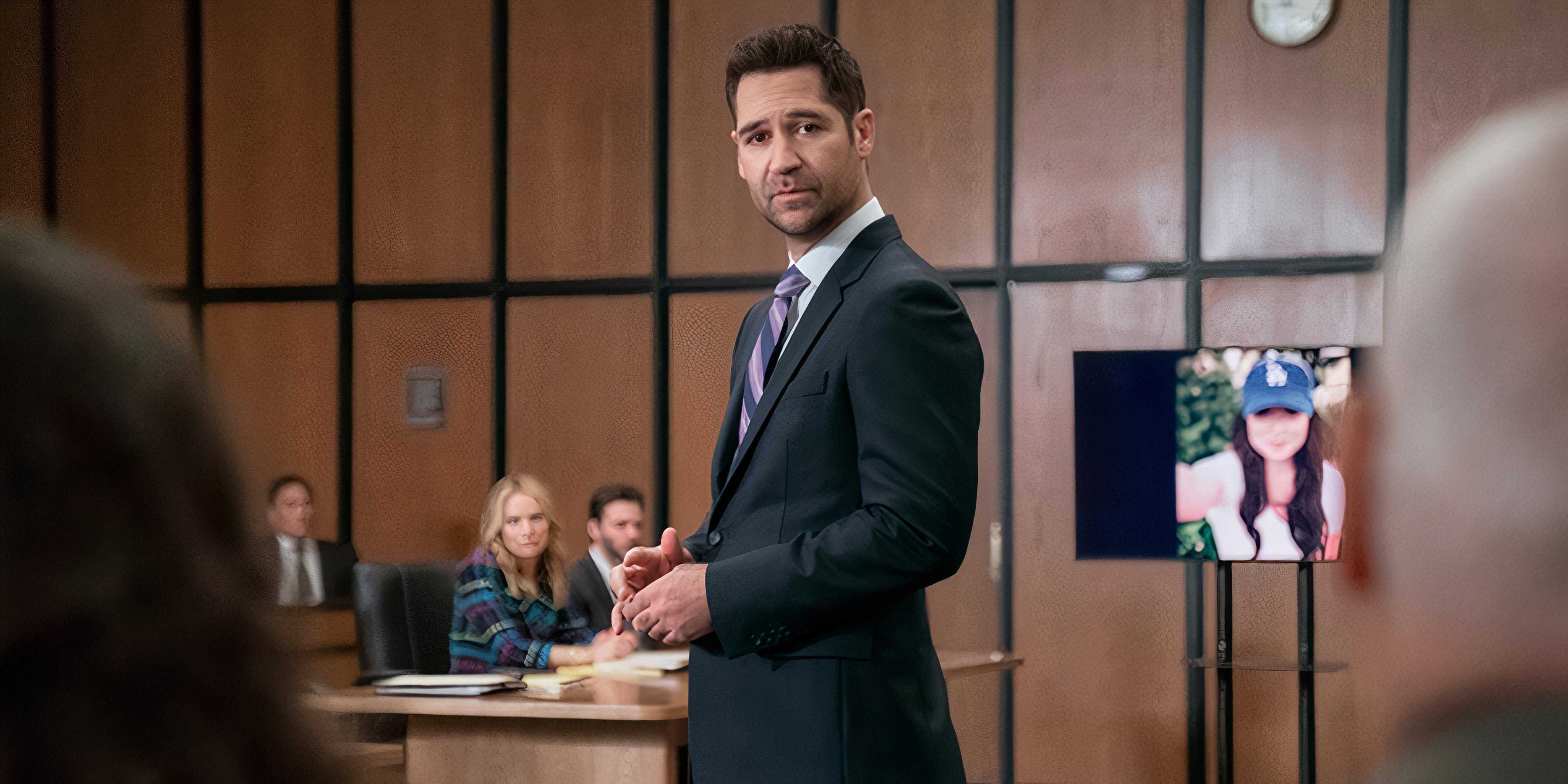 Mickey stands in the courtroom with a picture of Glory Days in the background in The Lincoln Lawyer season 3 episode 6