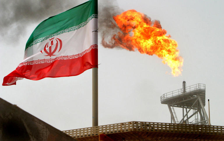 An oil production platform alongside an Iranian flag. The latest sanctions name services providers in the Emirates, Hong Kong, China and elsewhere.