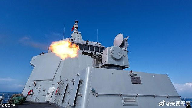 A still image showed at least ten empty munitions' shells scattered on the deck in the middle of live firing exercises (pictured)