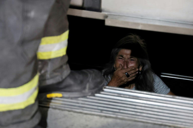 Una persona mayor atrapada en un ascensor es asistida por bomberos durante un apagón en Santiago el 25 de febrero de 2025